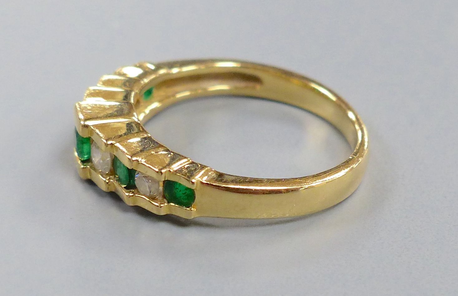 An Art Deco style emerald and diamond nine-stone ring in stepped setting, stamped 14K, size K, gross 3.5 grams.